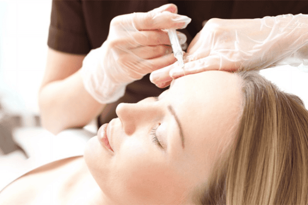 Close-up of a woman receiving a facial injectable treatment, highlighting the importance of careful treatment planning for balanced facial aesthetics.